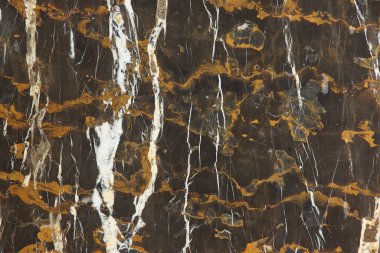 Doğal taşın levhası kahverengi mermerdir. Sarı ve beyaz çizgileri vardır. Siyah ve Altın olarak adlandırılır..