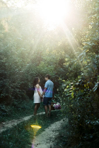 Man en zwangere vrouw wandelen in het park — Stockfoto