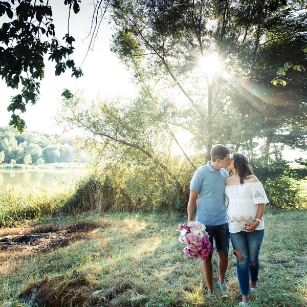 Homem e mulher grávida andando no parque — Fotografia de Stock