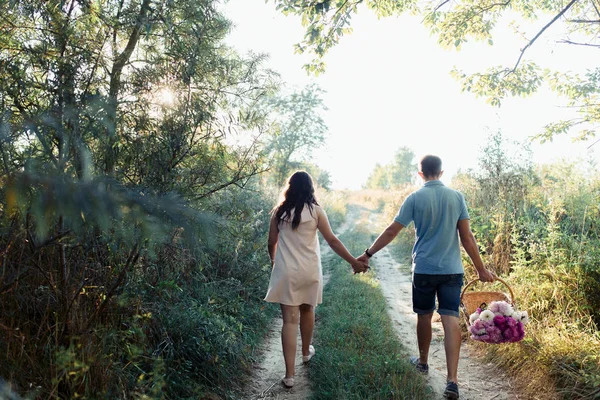 Uomo e donna incinta che camminano sul campo — Foto Stock