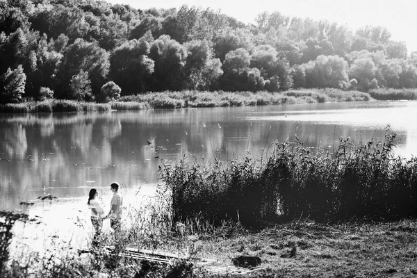 Man en zwangere vrouw in de buurt van rivier — Stockfoto