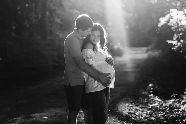 Man en zwangere vrouw wandelen in het park — Stockfoto