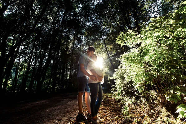 Man en zwangere vrouw wandelen in het park — Stockfoto