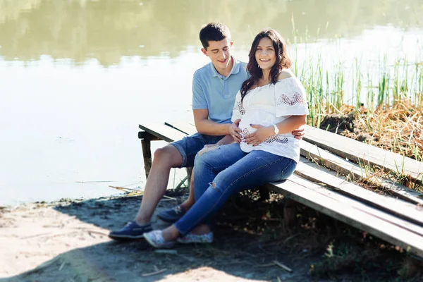Чоловік і вагітна жінка біля озера — стокове фото