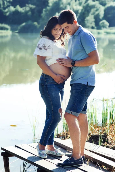 Homem e mulher grávida perto do lago — Fotografia de Stock