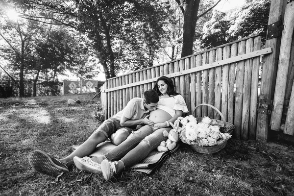 Homme et femme enceinte près d'une clôture en bois — Photo