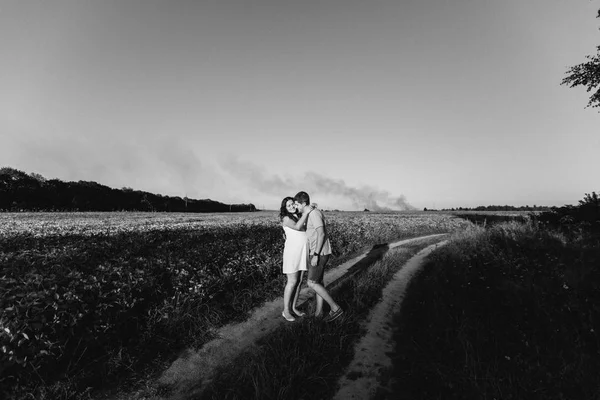 Homme et femme enceinte marchant dans le champ — Photo