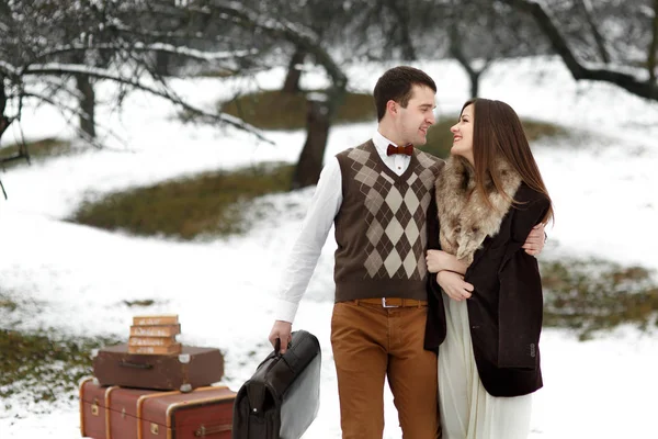 Coppia amorevole con valigie nel parco invernale — Foto Stock