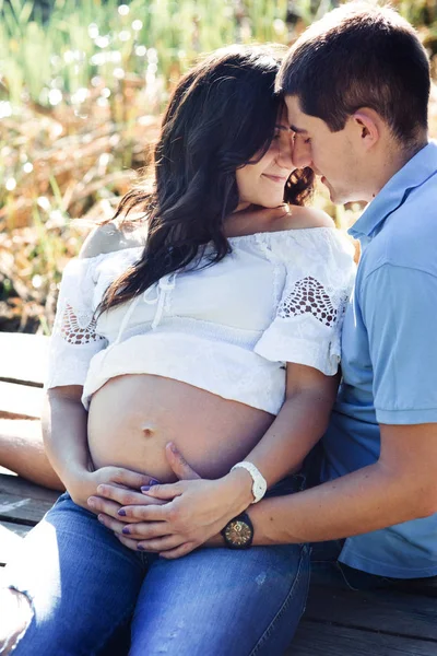 Homme et femme enceinte près du lac — Photo