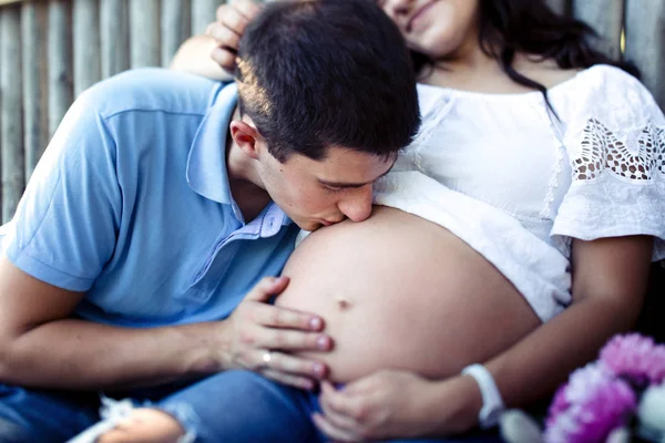 Uomo e donna incinta vicino alla recinzione in legno — Foto Stock