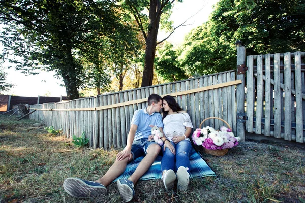 Uomo e donna incinta vicino alla recinzione in legno — Foto Stock