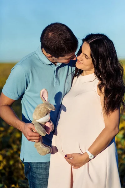 Homme et femme enceinte marchant dans la prairie — Photo