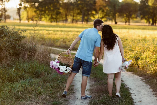 Homem e mulher grávida andando no prado — Fotografia de Stock