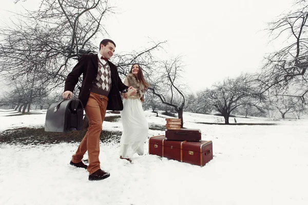 Verliefde paar met koffers in winter park — Stockfoto