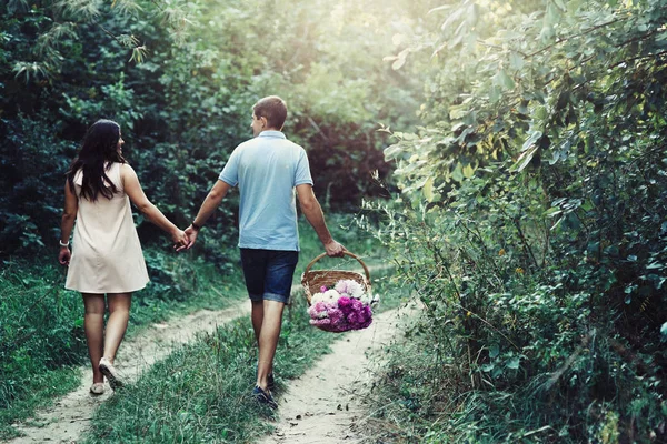 Man en zwangere vrouw wandelen in veld — Stockfoto