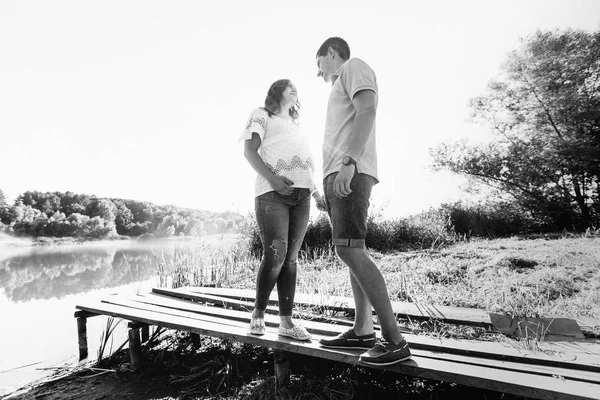 Uomo e donna incinta vicino al fiume — Foto Stock