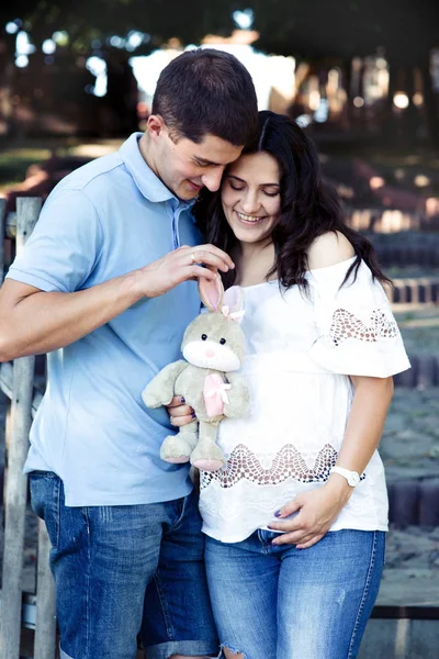 Hombre y mujer embarazada cerca de valla de madera — Foto de Stock