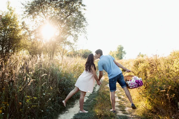 Uomo e donna incinta che camminano sul campo — Foto Stock