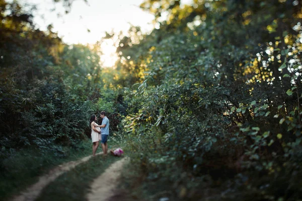 Homme et femme enceinte marchant dans le champ — Photo