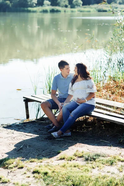 Чоловік і вагітна жінка біля озера — стокове фото