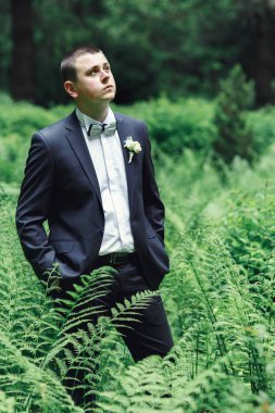 Damat yeşil ormanda yürür