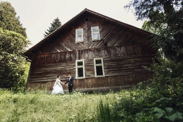 Braut und Bräutigam vor altem Holzhaus — Stockfoto