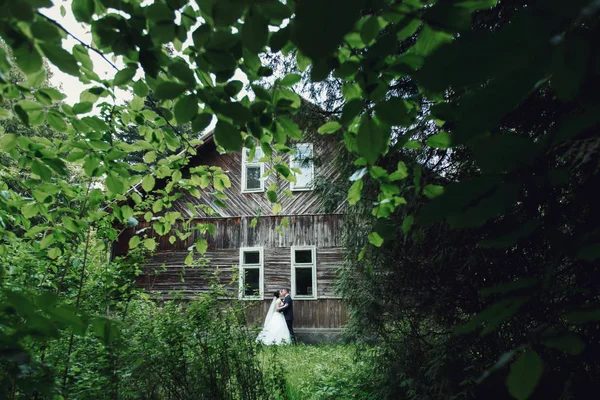 Braut und Bräutigam vor altem Holzhaus — Stockfoto