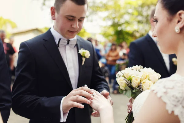 Brudgummen sätter ringen på brudens hand — Stockfoto