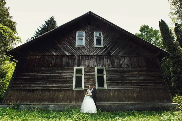 Braut und Bräutigam vor altem Holzhaus — Stockfoto