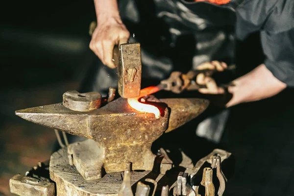 Blacksmith works with hot red steel — Stock Photo, Image