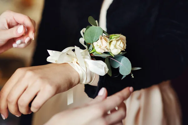 Braut legt Brautjungfern Blumen ans Handgelenk — Stockfoto