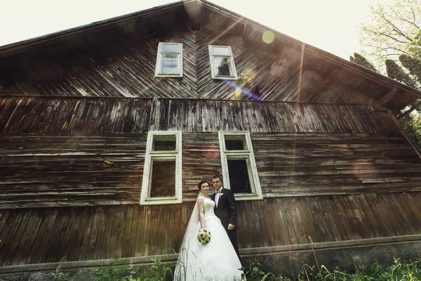 Braut und Bräutigam vor altem Holzhaus — Stockfoto