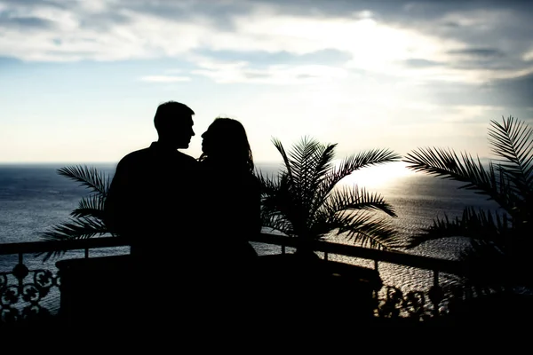 Силуэты пары, смотрящей на закат — стоковое фото
