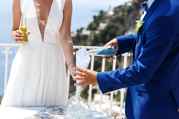 Recién casados vierten arena en botella de vidrio —  Fotos de Stock