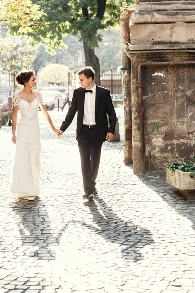 Recém-casados em um passeio perto de edifício antigo — Fotografia de Stock