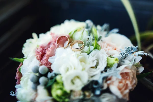 Golden wedding rings on wedding bouquet — Stock Photo, Image