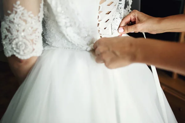 Dama de honor ayudando a la novia a vestirse — Foto de Stock