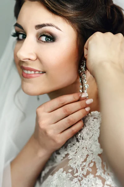 Красивая невеста надевает блестящие серьги — стоковое фото