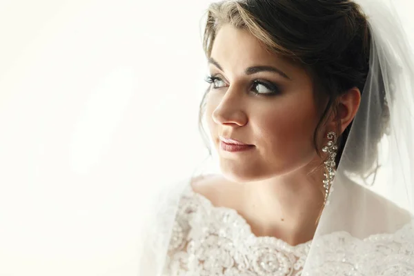 Elegante novia en vestido de encaje por ventana — Foto de Stock