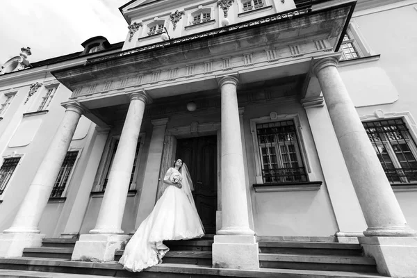 Великолепная невеста у старого здания с деревянной дверью — стоковое фото