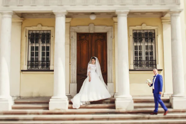 Recién casados por edificio viejo con puerta de madera —  Fotos de Stock