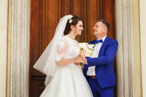 Newlyweds by old wooden door — Stock Photo, Image