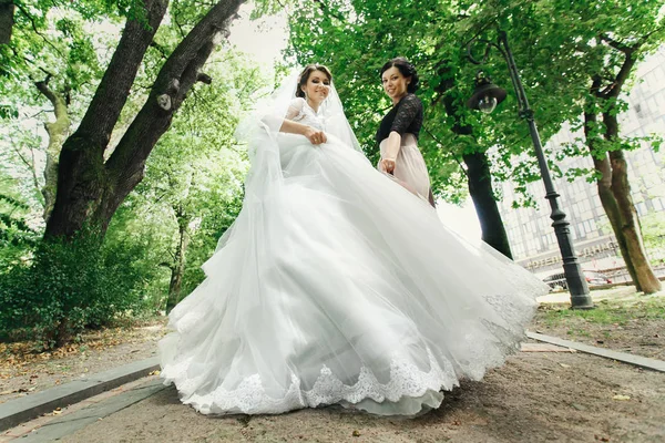 Braut und Brautjungfer posieren im Park — Stockfoto