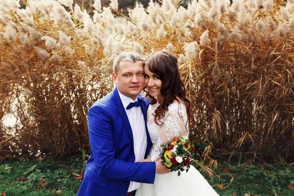 Hermosa pareja de boda por el lago de otoño — Foto de Stock