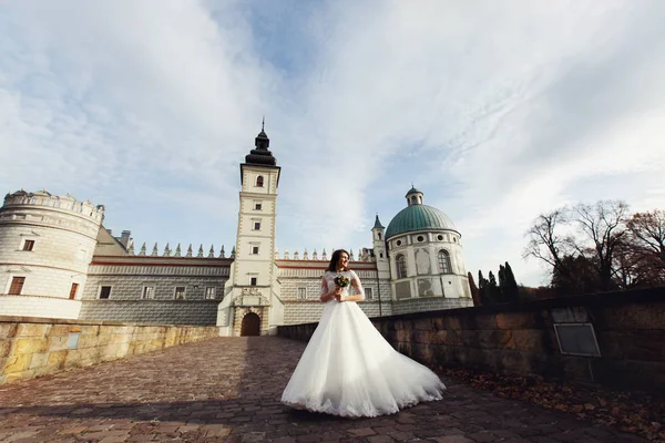 Braut in prachtvollem Kleid am alten Schloss — Stockfoto