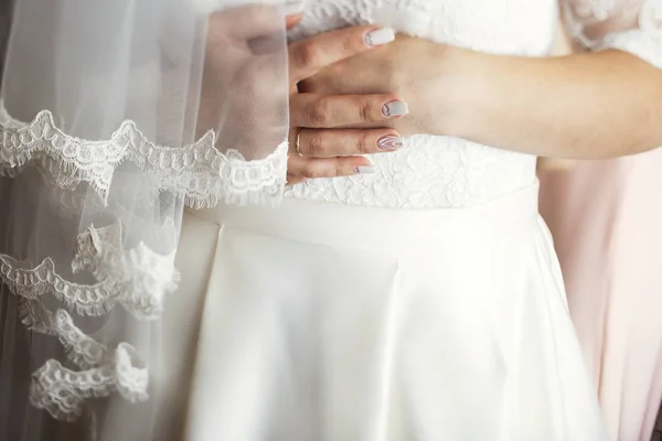 Невеста держит руки скрещенными на животе — стоковое фото