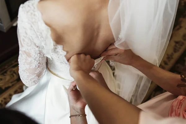 Damas de honor ayudando a la novia a vestirse —  Fotos de Stock
