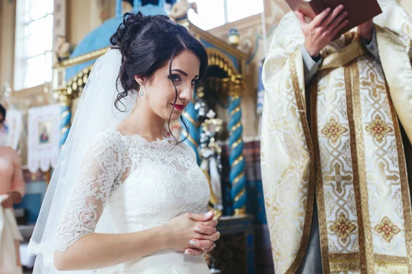 Невеста в церкви во время свадебной церемонии — стоковое фото