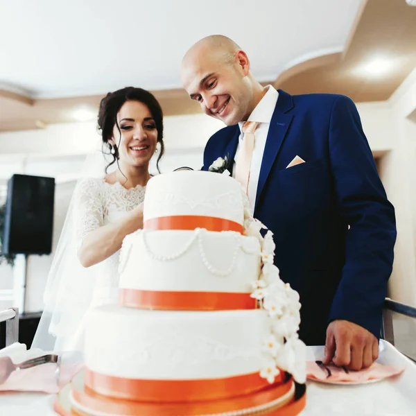 Recém-casados cortando bolo de casamento — Fotografia de Stock