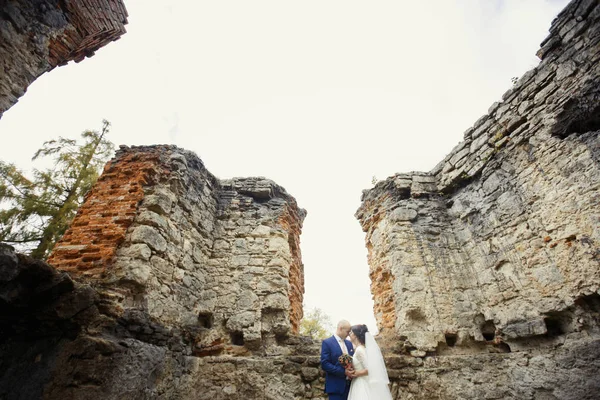 Groom and charming bride by ruins — Stock Photo, Image